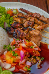 Grilled skewers with rice and fresh salad, perfect for a delicious meal or restaurant menu