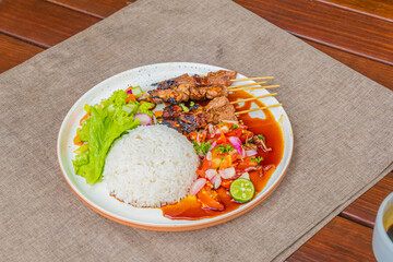 Delicious grilled satay with rice and fresh salad on plate ready to eat for lunch or dinner