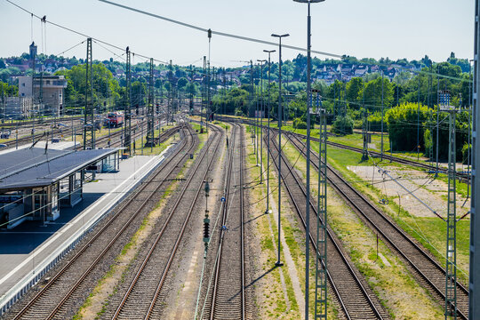 Lines of steel converge in silence at Heilbronn station, framed by clear skies and sharp contrasts.