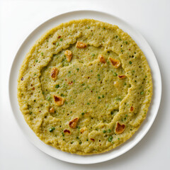 A traditional South Indian green gram pancake, known as pesarattu dosa, served plain on a clean