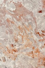 Natural stone texture with earthy tones of gray and rusty orange, showcasing rough surface patterns and organic details, ideal for backgrounds or design elements.