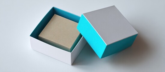 Open box with object inside, blue accents. Square-shaped on white surface