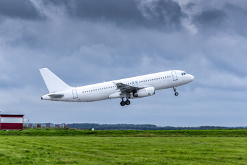Modern white passenger airliner takes off runway in cloudy weather