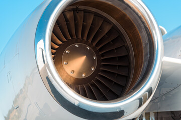 Tight close-up of a polished aircraft jet engine intake, the engine is mounted on the right side of...