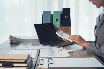 Close u[ view of young smart businesswoman esteming and calculating the cost of budget with calculator in the office room.