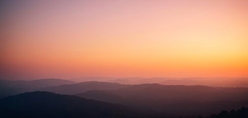 Fototapeta premium Serene mountain landscape at dawn with soft pastel sky and layered peaks
