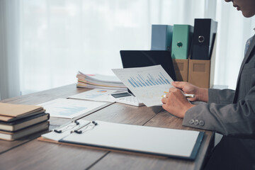 Collaborative business meeting featuring a team reviewing financial charts and a tablet device, Corporate analysis and reporting of data with a team approach to office technology