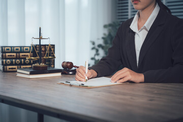 Focused Counsel: A professional individual meticulously pens important documents at a desk, the tools of their trade - a gavel, scales of justice.