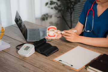 Medical Consultation: A healthcare professional, clad in professional attire, provides a detailed demonstration on dental health using a model.