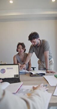 A young couple at a bank meeting excitedly secures a credit, receiving positive news from the manager. They shake hands, filled with joy and relief for their financial future.