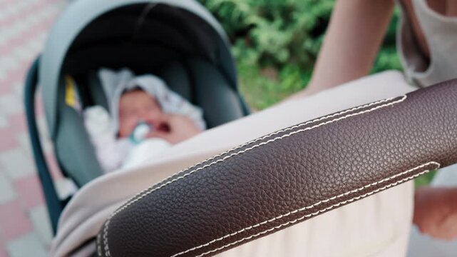Close up of a mother placing a pacifier into a baby's mouth while seated in a stroller