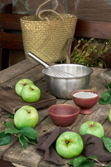 Rustic still life of fresh green apples, organic eggs, flour, brown cane sugar and natural ingredients for a homemade traditional apple pie preparation in a cozy countryside kitchen setting 