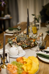 Festive Autumn Table Setting with Candles and Pumpkin