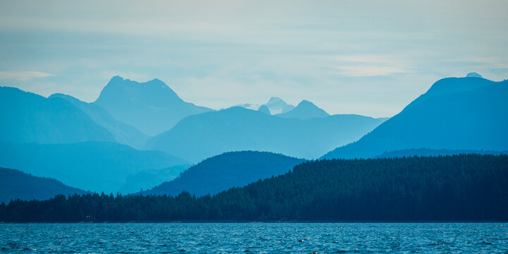 Layers of mountains on the West Coast of Canada on a hazy, early summer morning 