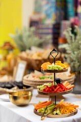 Freshly cut vegetable sticks arranged on a tiered wooden stand, offering a healthy and vibrant catering option