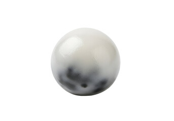 A glossy, round, off-white object with dark gray speckled patterns is highlighted against a pure black background.
