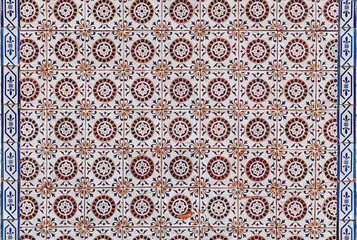 Typical old brown azulejos on the facade of a residential building in Portugal.