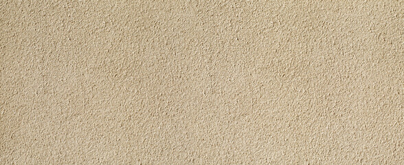 Beige textured plaster wall background providing copy space