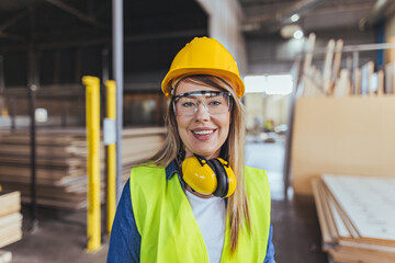 Smiling Female Construction Worker Wearing Safety Gear at an Industrial Job Site