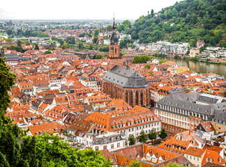 Naklejka premium Heidelberg's red-tiled roof skyline meets the Neckar in a serene July 2025 aerial.