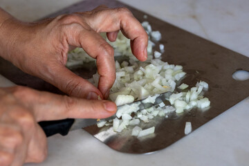 Chopping Onions with a Knife on a Metal Cutting Board