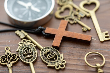 Vintage Compass, Cross, and Old Keys on a Wooden Table: A Nostalgic Still Life