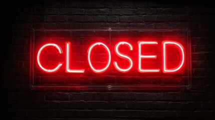 A vibrant neon sign illuminates the word "CLOSED" against a dark brick wall, signaling closure or inactivity.