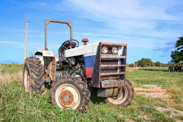 Agricultural tractor painted with the Russian (Russia) Flag, outside on the farm in a rural area. Low angle view.