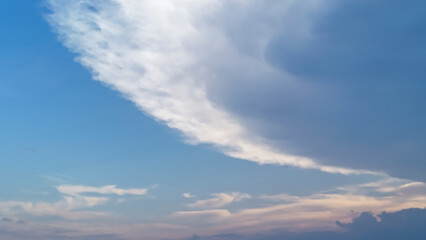 Fototapeta premium Vibrant sky features dramatic clouds contrasting with a clear blue backdrop, capturing the beauty of nature during the transition from day to evening.