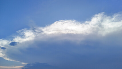 A serene sky scene featuring soft, fluffy clouds illuminated by sunlight against a blue backdrop. Ideal for nature and weather themes in various projects.