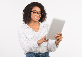 Fototapeta premium Checking Schedule. Smiling black woman checking appointment on personal tablet over white background, copy space