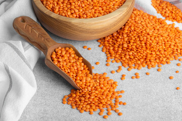 Red lentils in wooden bowl and spoon. Healthy Gluten-Free legume rich in protein, fiber, vitamins...