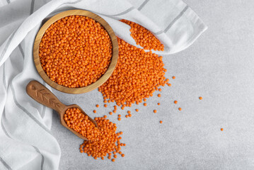 Red lentils in wooden bowl and spoon. Healthy Gluten-Free legume rich in protein, fiber, vitamins...