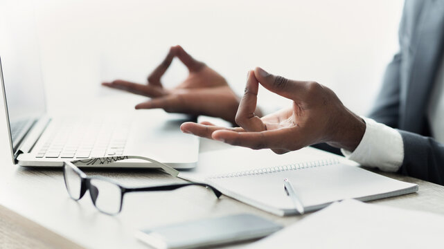Closeup of African American Businessman Meditating In Office, Practicing Yoga At Work, Trying To Handle Stress About Deadline. Panorama with free space - Powered by Adobe