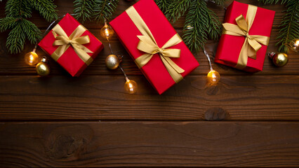 A cozy Christmas-themed flat lay featuring wrapped gift boxes, pine branches, golden ornaments, and warm fairy lights arranged on a rustic wooden background. Ideal for holiday marketing, seasonal prom