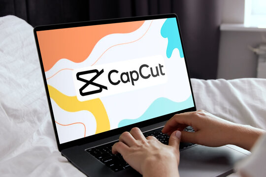 Editor using capcut video editing software on laptop in bed