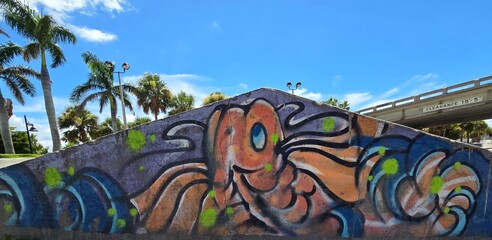 Colorful graffiti fish mural on wall with palm trees Bradenton Fl 07/20/2025