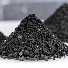 Dark soil piles on white surface