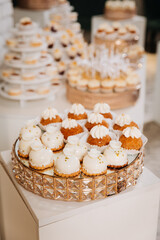 Elegant vanilla cream profiteroles on a golden stand at festive dessert table display