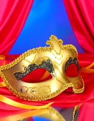 Golden Venetian mask on red and blue drapes