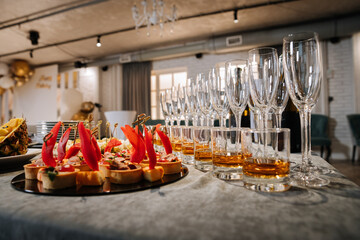 Luxury banquet table with whiskey, champagne flutes, and gourmet appetizers at event