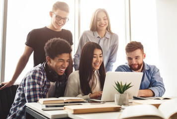 Learning concept. Diverse students preparing for exams in library, using laptop together
