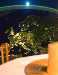 Earth view from space over Europe at night, seen through a table setting