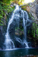 Obraz premium Tall waterfall over rocky cliff