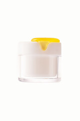 Glass cosmetic jar with honey dripping on white background