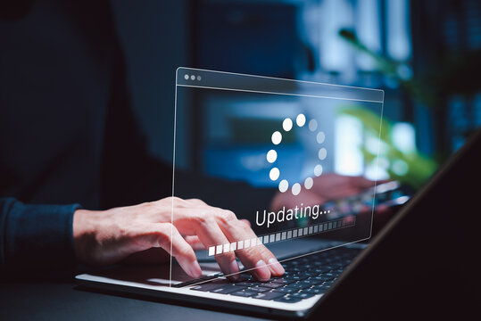 Software Update and System Upgrade Concept. Person holding phone while using laptop with software update progress interface and security, technology maintenance, application upgrades, system security.