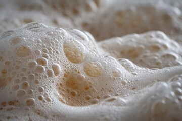 Bubbles and foam creating texture in a fresh batch of brewed beverage in warm tones