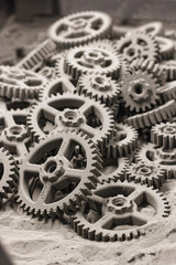 A pile of SLS 3D Printed gears or cogs, freshly out of the powder and undergoing cleaning process.