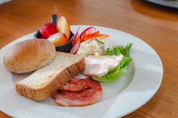 Healthy breakfast plate with bread, ham, chicken and fresh salad

