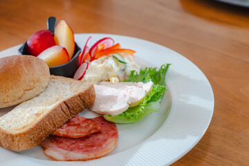 Healthy breakfast plate with bread, ham, chicken and fresh salad
